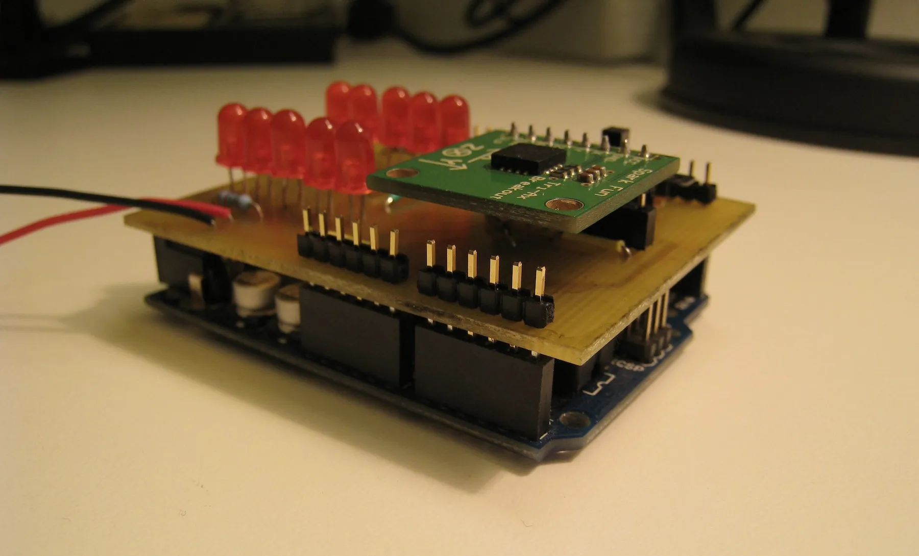 Home-etched shield with ten red LEDs and a SparkFun accelerometer breakout, stacked on an Arduino