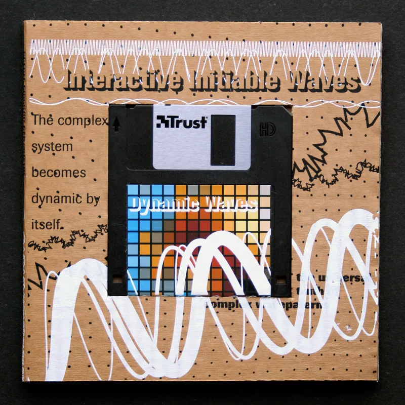 The floppy in its cardboard sleeve: a grid of blue, red and orange squares on the label, white painted waves, and the line The complex system becomes dynamic by itself