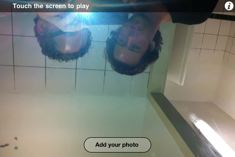 Browse mode: an upside-down mirror shot of two people in a tiled washroom, with Touch the screen to play and an Add your photo button