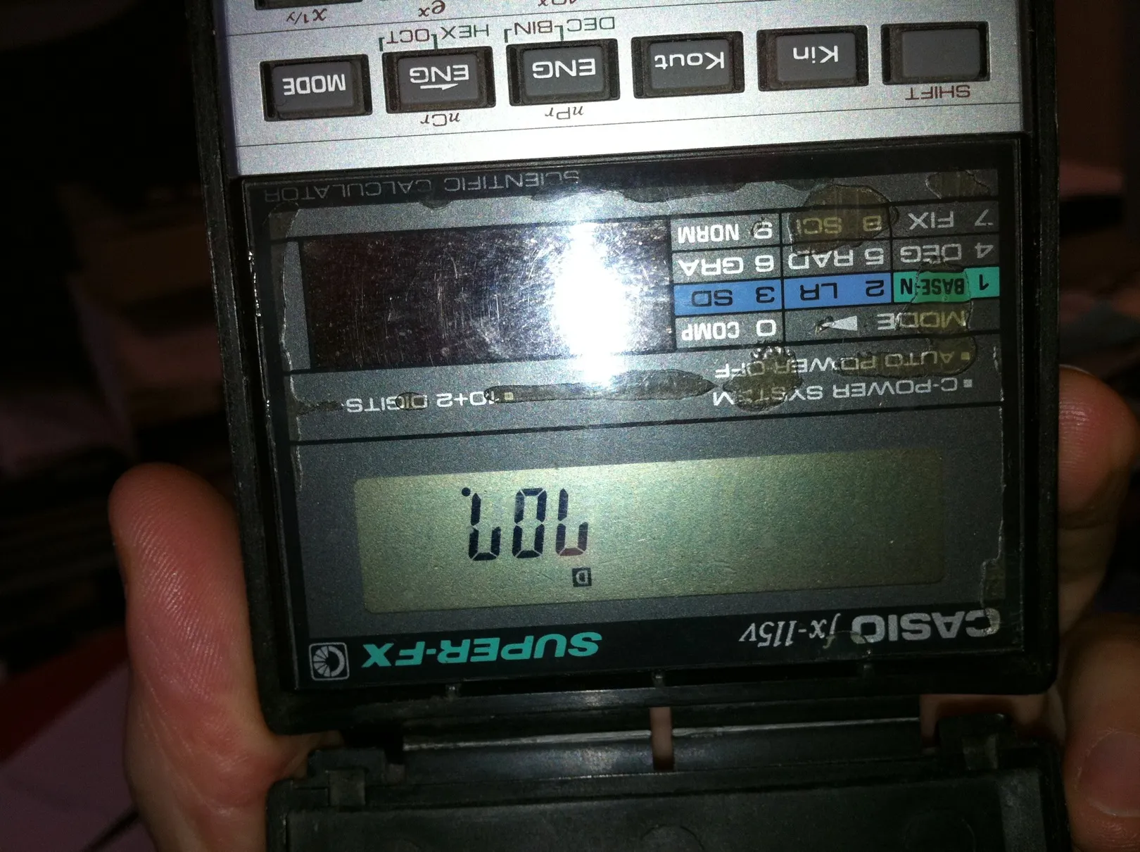 An old Casio calculator held upside down so the display reads LOL, the flash reflected in its label