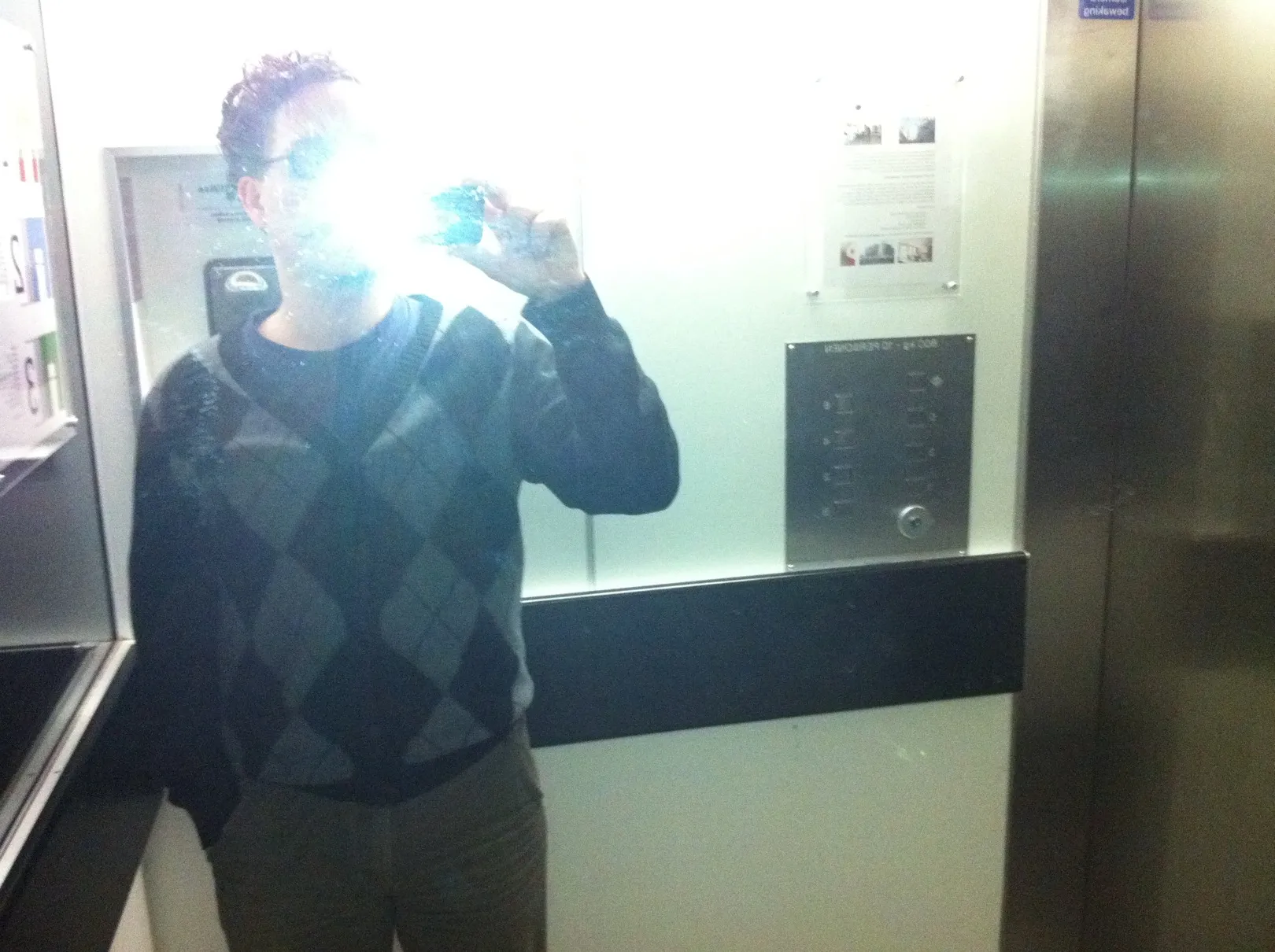 A mirror shot in a lift, the flash blowing out the face of the person holding the phone