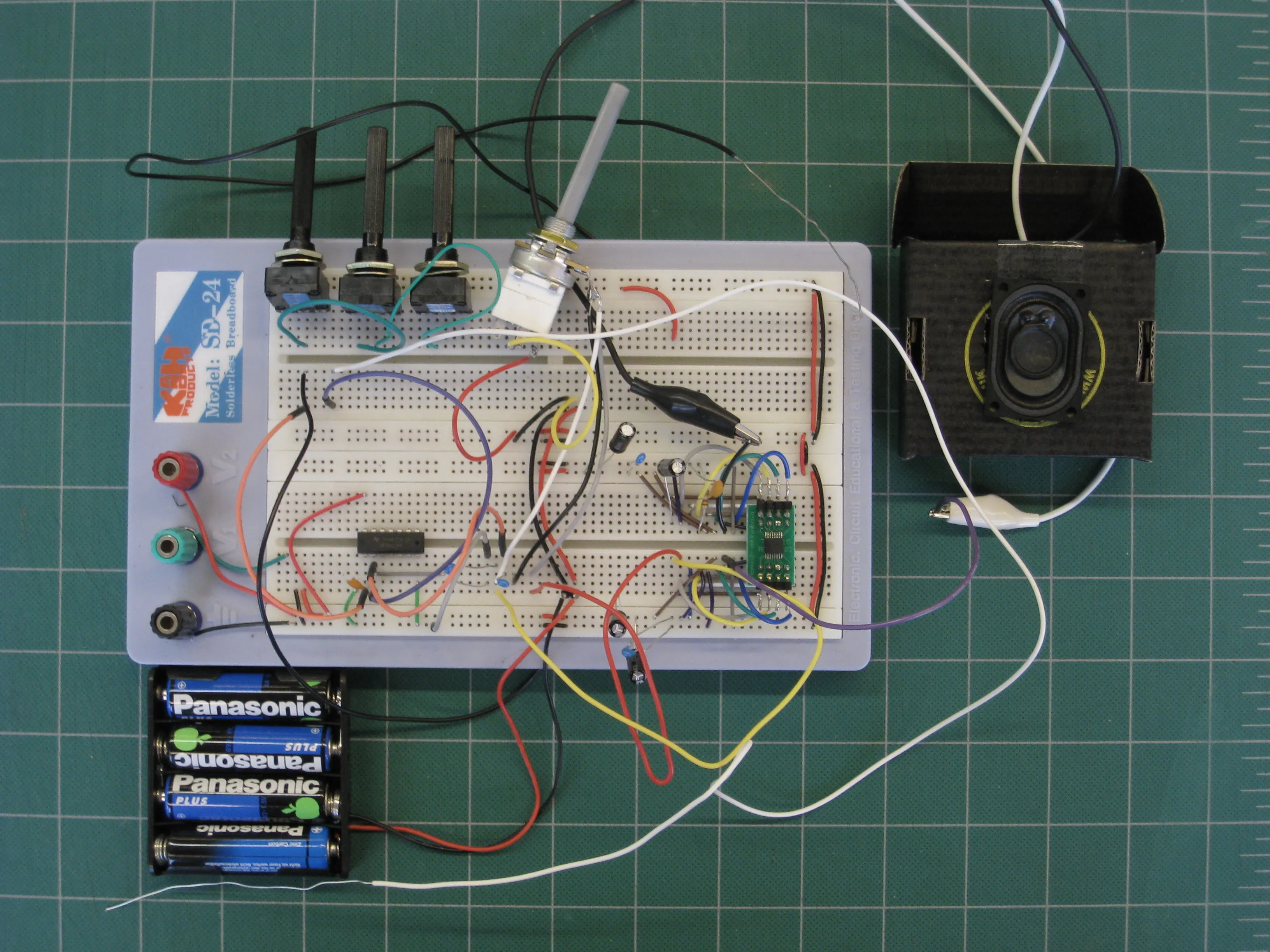 The working breadboard version, with trimmers, a volume potentiometer, a pack of four batteries and a small speaker in a box