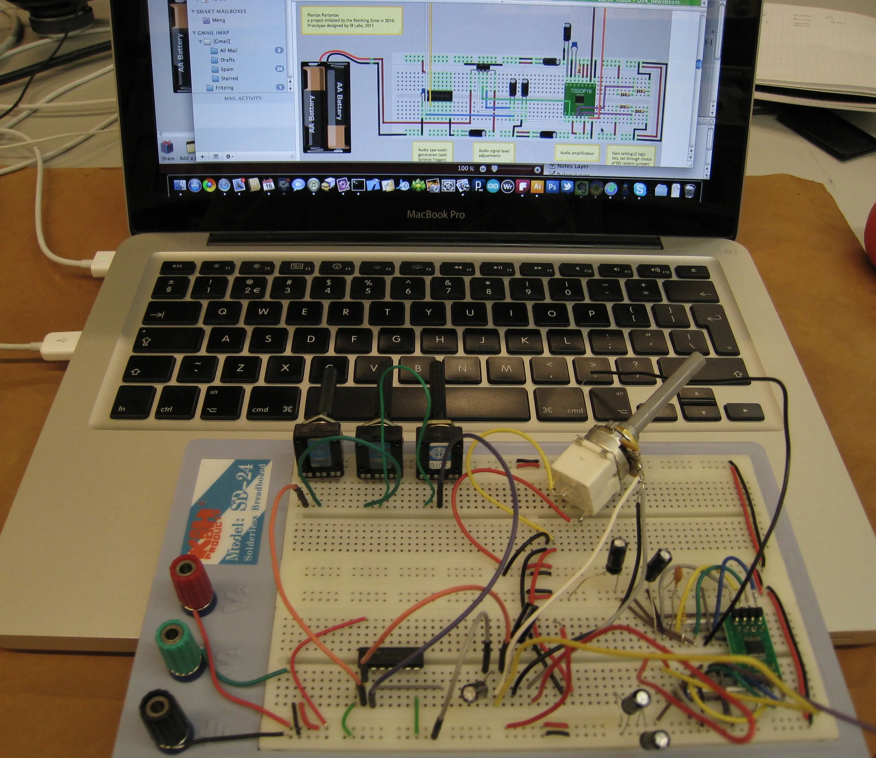 The breadboard in front of a laptop showing the same circuit drawn in Fritzing