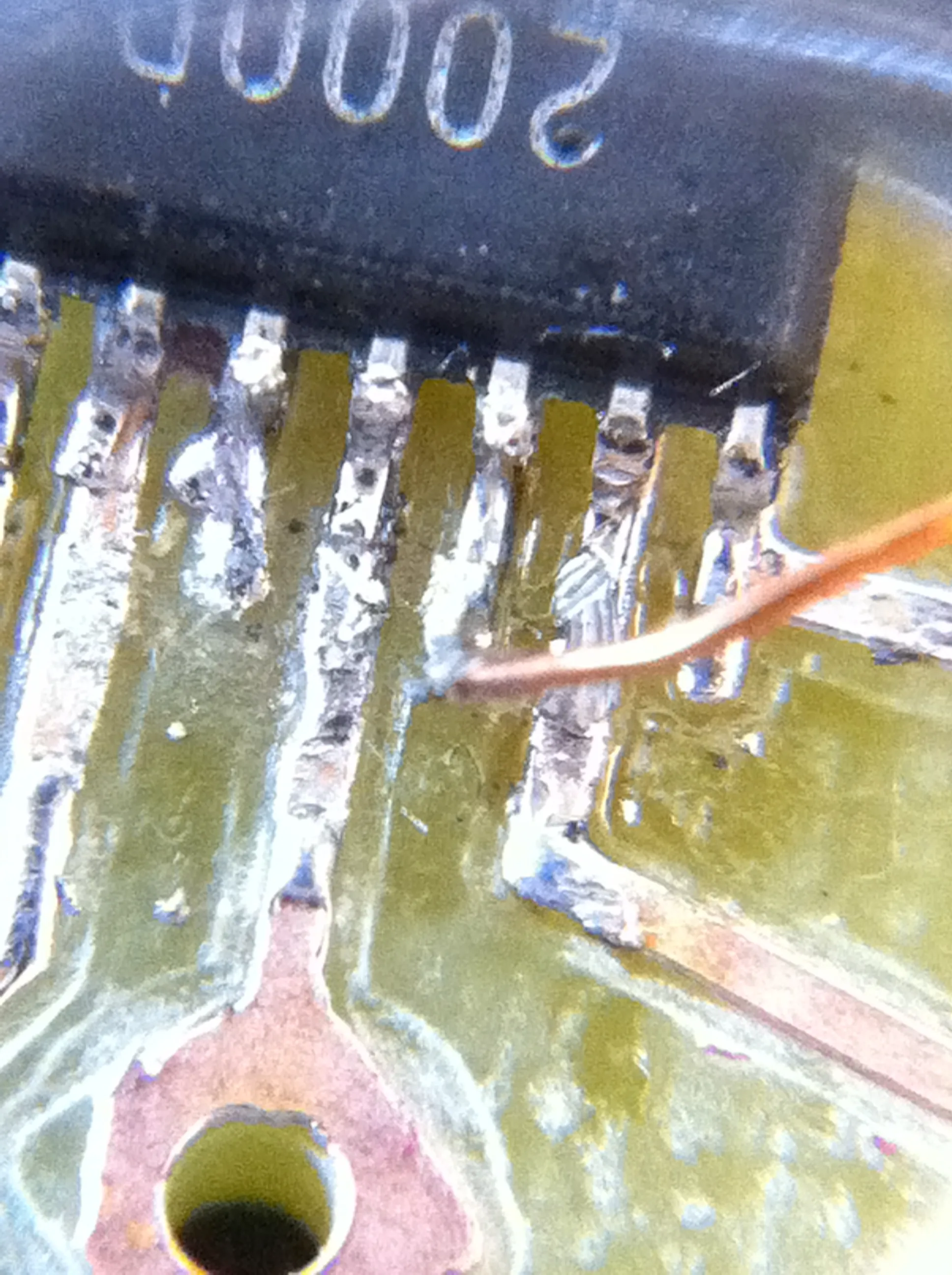 Macro shot of the amplifier chip's legs soldered to the board, with a thin copper wire patched onto one pin