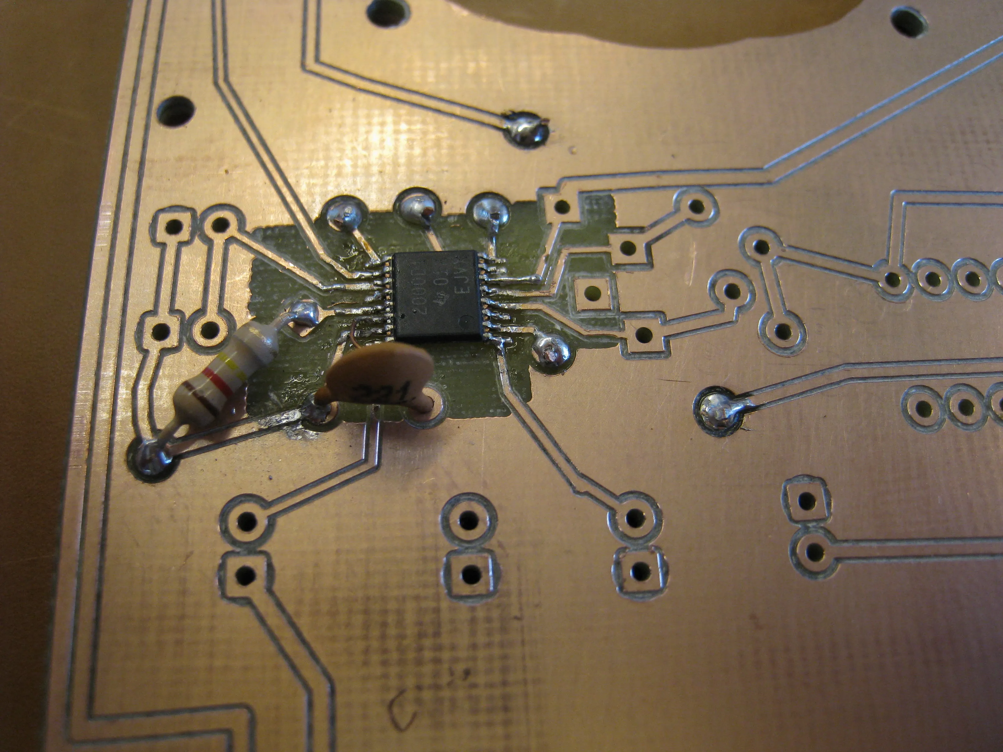 The amplifier chip soldered in place with its first resistor and ceramic capacitor