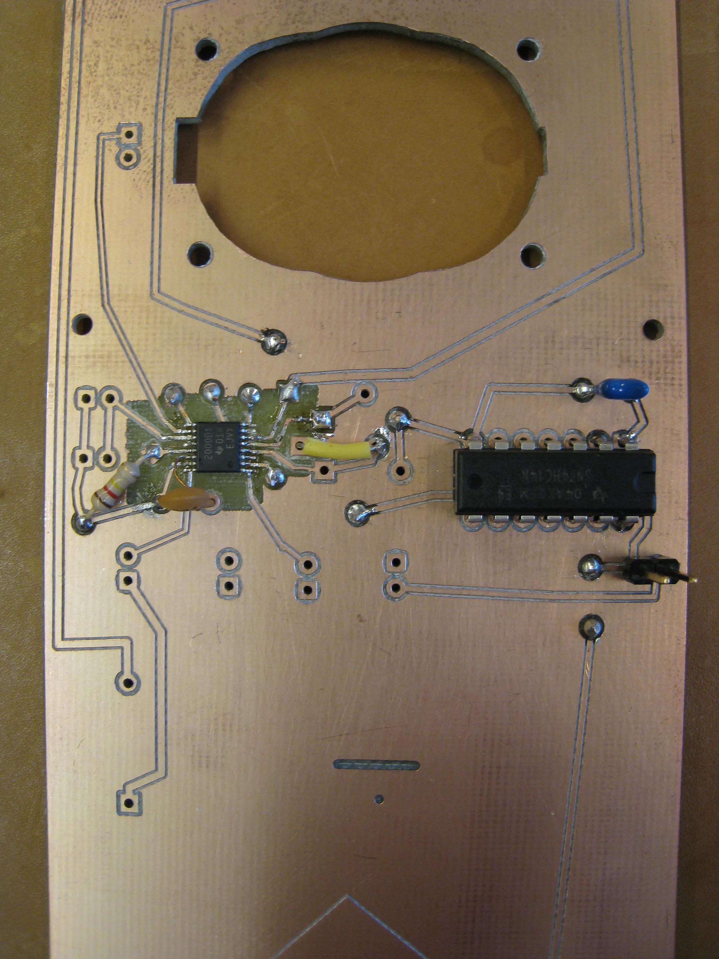 The board with the surface-mount amplifier and a 14-pin chip soldered on, below the speaker cutout