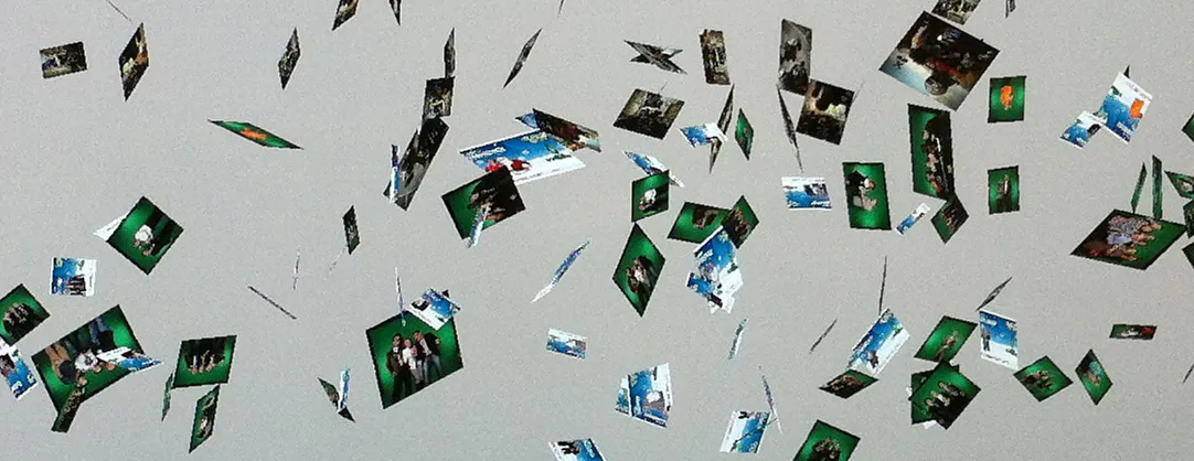 Close-up of the photo cloud: portraits turning in space, many against a green background