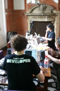 The developer seen from behind, in an Intellistener DEVELOPER t-shirt, among the workshop tables