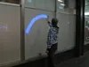 Using a mobile phone to write graffiti on a glass wall