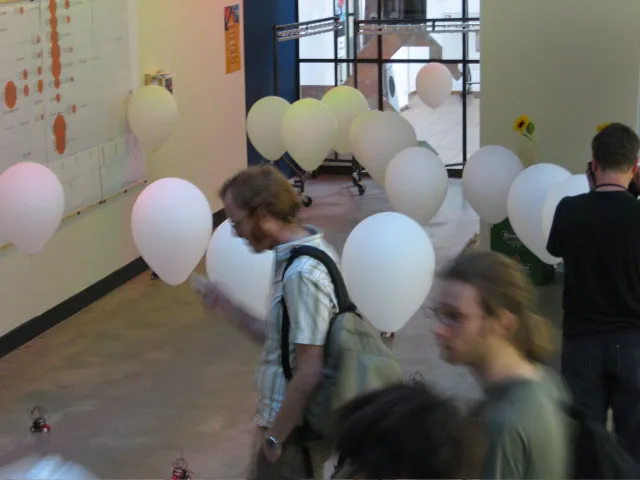 Visitors walking between the balloons, robots on the floor below them