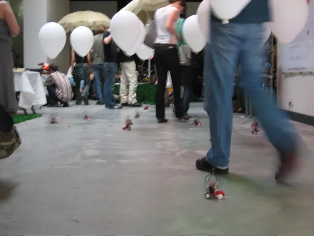 Low view of a visitor walking through the flock, a robot right at their feet
